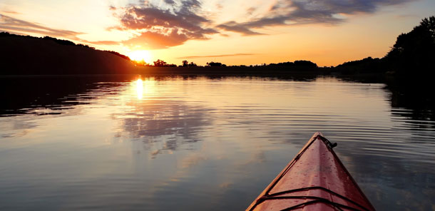 Picture of the sunsetting while on a kayak in the river.
